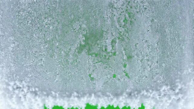Frost freezing from top to bottom on green screen
