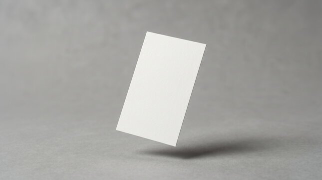Minimalist floating business card mockup, blank white paper card on grey concrete background, professional stationery template for branding