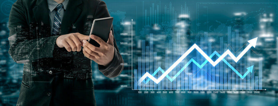 A businessman uses a smartphone to analyze financial data while digital graphs display growth trends and city skyline. Perfect for themes of business strategy and development. Scalp