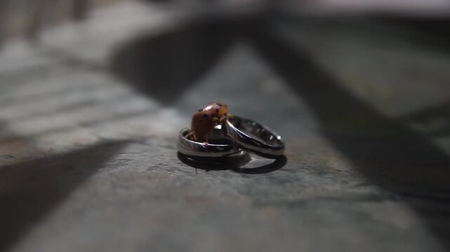 Cinematic slow-motion shot featuring a pair of silver and gold wedding bands. Highlighting sparkling diamond details, fine craftsmanship, and romantic atmosphere for matrimony, proposal, or anniversar