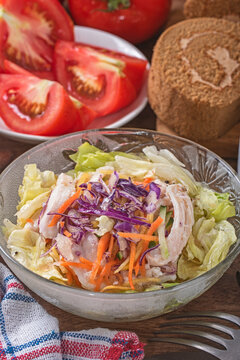 Shredded chicken salad with scallion and sald dressing in glass bowl