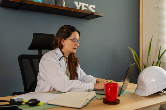 Female doctor working on laptop for occupational health