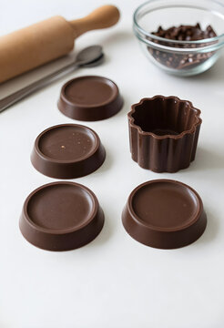 Homemade chocolate molds and baking ingredients on a white kitchen counter dessert preparation and confectionery, this setup dessert preparation confectionery and the culinary process of making