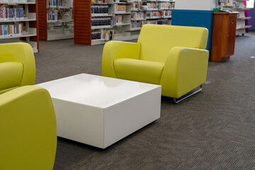 Modern public library interior with yellow armchairs and bookshelves © Olha Semeniv