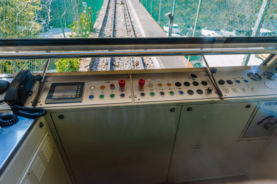 Control panel of a funicular railway with buttons and levers, overlooking the tracks and green landscape in Bergamo, Lombardy