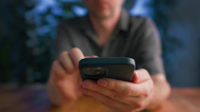 Modern office worker or freelancer using a smartphone in a stylish loft studio. Mobile communication, remote work, digital technology, creative business, productivity and modern workspace.