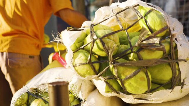 Vendor Removing Chayote from a Sack at a Local Market