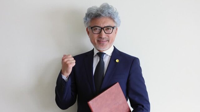 ファイルを抱えてガッツポーズをする弁護士