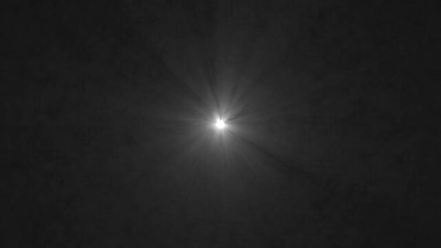 Bright starburst light in dark night sky