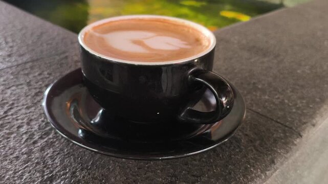 A person enjoying a cup of hot mochaccino topped with creamy foam, creating a cozy and relaxing caf&eacute; moment with rich coffee and chocolate flavors, perfect for lifestyle photography.