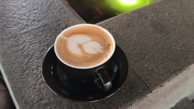 A person enjoying a cup of hot mochaccino topped with creamy foam, creating a cozy and relaxing caf&eacute; moment with rich coffee and chocolate flavors, perfect for lifestyle photography.