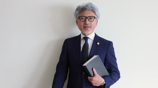 法律書を抱えてガッツポーズをする弁護士
