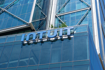 Fototapeta premium Toronto, Ontario, Canada - August 5, 2026: Close up of Intuit logo sign on the building at their Canadian Headquarters at The Well on Spadina Ave in downtown Toronto, Canada. Intuit Inc is an America