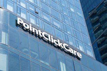 Fototapeta premium Toronto, Ontario, Canada - August 5, 2026: Close up of PointClickCare sign on the building at The Well on Spadina Ave in downtown Toronto, Canada. PointClickCare Technologies is a healthcare software
