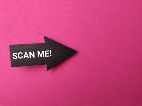 A black arrow wooden clip with text reading SCAN ME! points right across a pink textured background