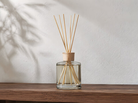 Glass reed diffuser bottle with wooden reeds on shelf