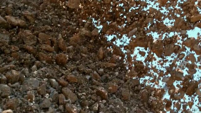 Industrial heavy machinery pouring gravel and soil at construction site
