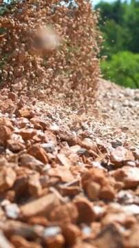 Industrial heavy machinery pouring brown gravel and rocks