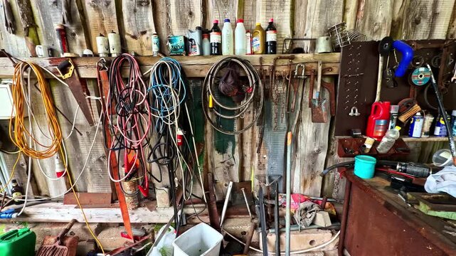 A gritty, detailed view of a rustic wooden workshop wall inside an old barn or garage.