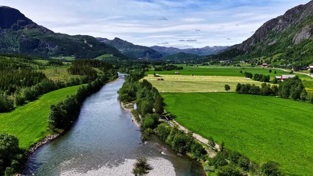 A Winding River Flows Through Lush Farmland and Mountains Along the Road From Fl&aring;m to Oslo, Norway - Aerial Drone Shot