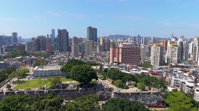 Aerial orbit around Mount Fortress and Macau Museum showcasing historic fortifications, gardens and panoramic Macau skyline