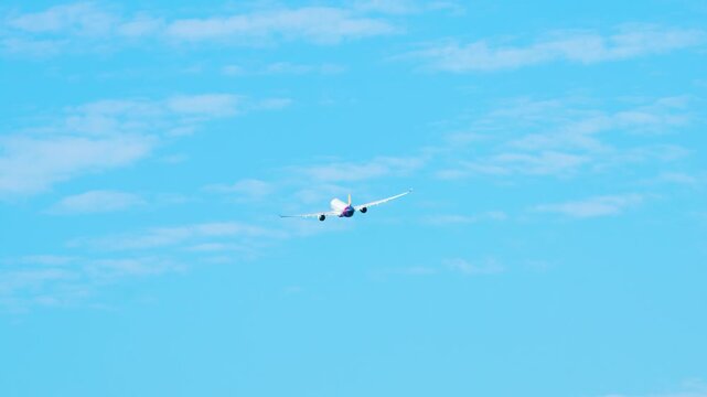 Passenger airplane takes off from Jeju International Airport and climbs into a clear blue sky above South Korea