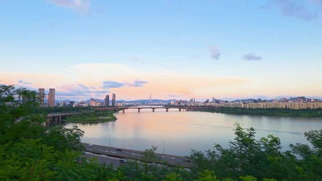View from Dalmaji Park shows Seongsu Bridge crossing the Han River with Seoul skyline, Lotte Tower, and expressway traffic at sunset