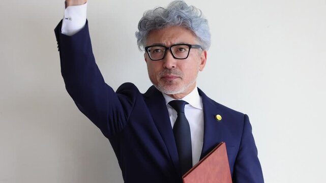 法廷で手を挙げて異議を申し立てる男性弁護士