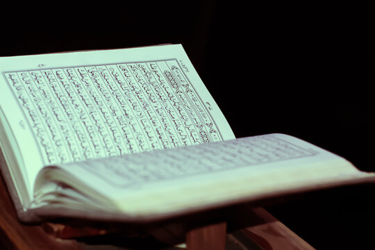 Open Holy Quran on wooden stand