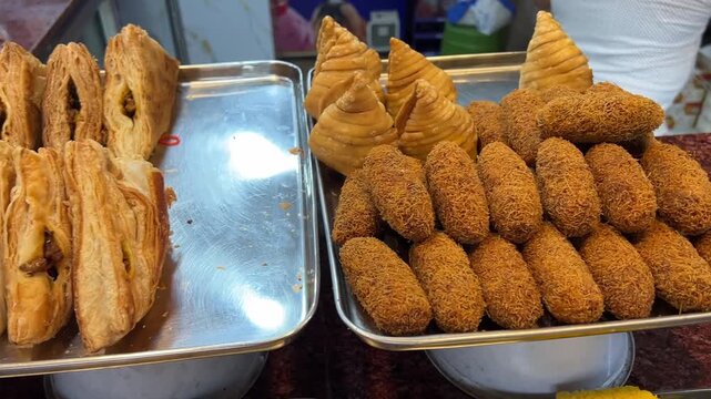 A mouth-watering close-up shot of an appetizing vegetarian snack platter featuring crisp samosas, vegetable chops, flaky patties, and a rich Raj kachori.