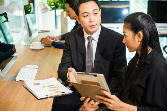 Two business people having meeting together discussing the charts and graphs showing the results