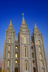 Fototapeta premium The Salt Lake Temple stands majestically in Temple Square in Salt Lake City, Utah, showcasing stunning Gothic and Romanesque architectural details. Its granite spires rise against a clear blue sky, su
