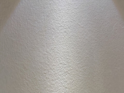 Natural white plaster wall texture showing subtle surface patterns and architectural material details, suitable for backgrounds, interior design concepts, construction materials, and minimal abstract 