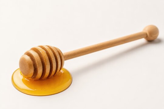 Wooden honey dipper in a pool of golden honey