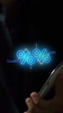 Cropped vertical shot of hand holding smartphone displaying glowing percentage icon with Quality up and Cost down indicators. Business cost reduction and quality optimization strategy concept.