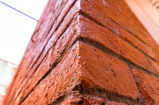 Low-angle view of a red brick pillar corner texture
