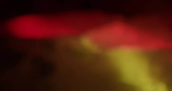 Bokeh texture. Yellow light. Pink warm color lens flare optical glisten kaleidoscope on abstract luminous dark black art background.