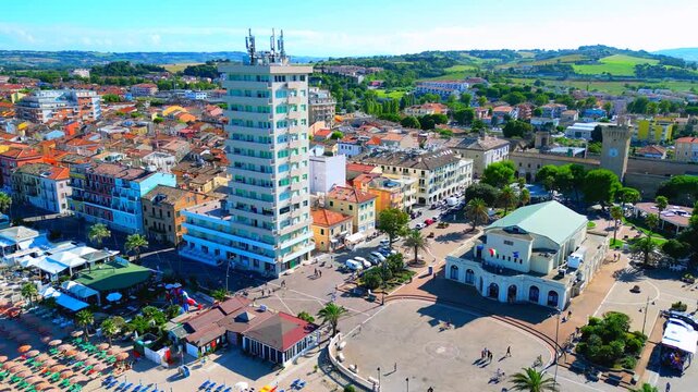 PORTO RECANATI, ITALY - JULY 30, 2025: Aerial truck left pan right arcing shot of Piazza Fratelli Brancondi. Dedicated to Italian anti-fascist brothers Paolo and Bruno, WWII resistance freedom heroes
