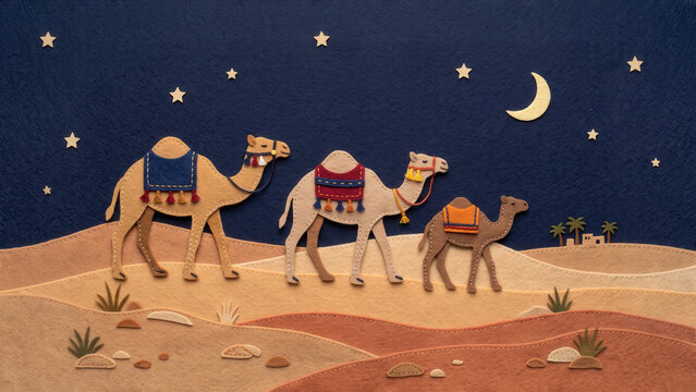 A handcrafted felt illustration of three camels with stitched saddles walking across layered desert dunes under a dark sky with stars and a crescent moon.
