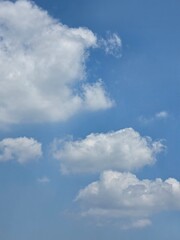 Fototapeta premium Layered white clouds floating across bright blue sky