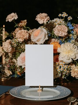 Blank place card framed by flowers on an elegant table setting