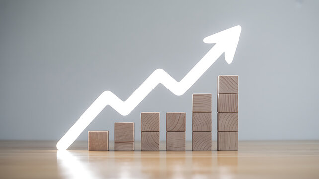 A growing bar chart made of wooden blocks features a white upward arrow against a plain.