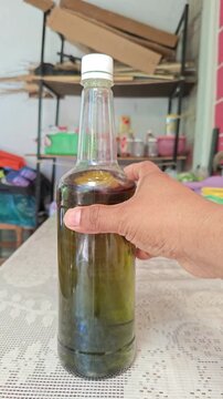 Glass Bottle of Organic Olive Oil on Table with Bamboo Background