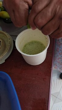 Squeezing Fresh Lime Juice into Tomato Juice Cup