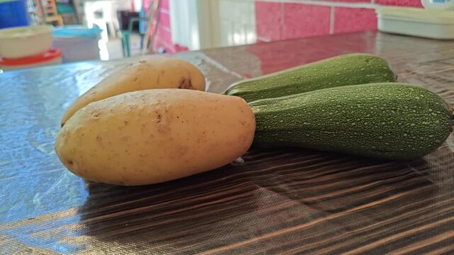 Fresh Potatoes and Green Zucchini Vegetables Displayed on Table