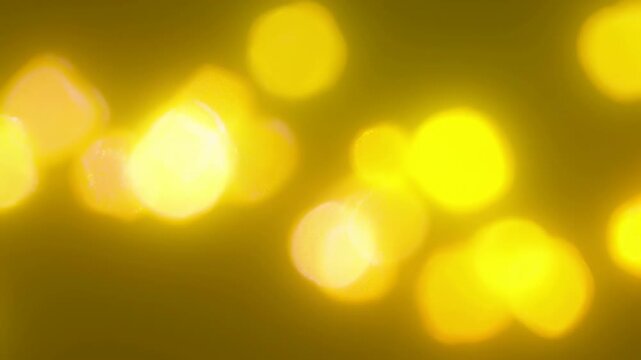 Abstract golden bokeh lights glowing softly across warm background with bright blurred circles, smooth amber tones, minimal composition, festive mood, dreamy luminous texture for decorative use