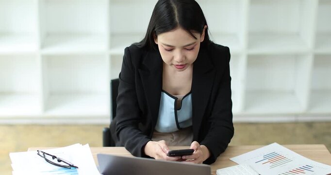 Young businesswoman analyzing financial documents and data, managing budget planning in a modern office