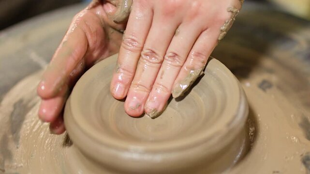 Close Up of Artisan Hands Shaping Clay on Pottery Wheel