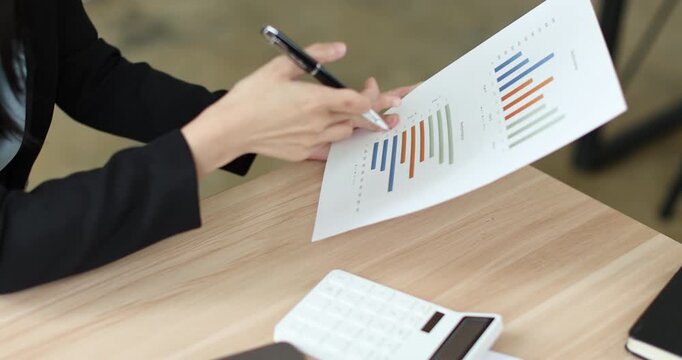 Businesswoman analyzing financial reports and working on laptop in modern office, managing business data