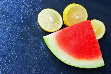 Fresh Watermelon Slice and Lemon Citrus on Dark Wet Background with Water Droplets © Maya Yulia